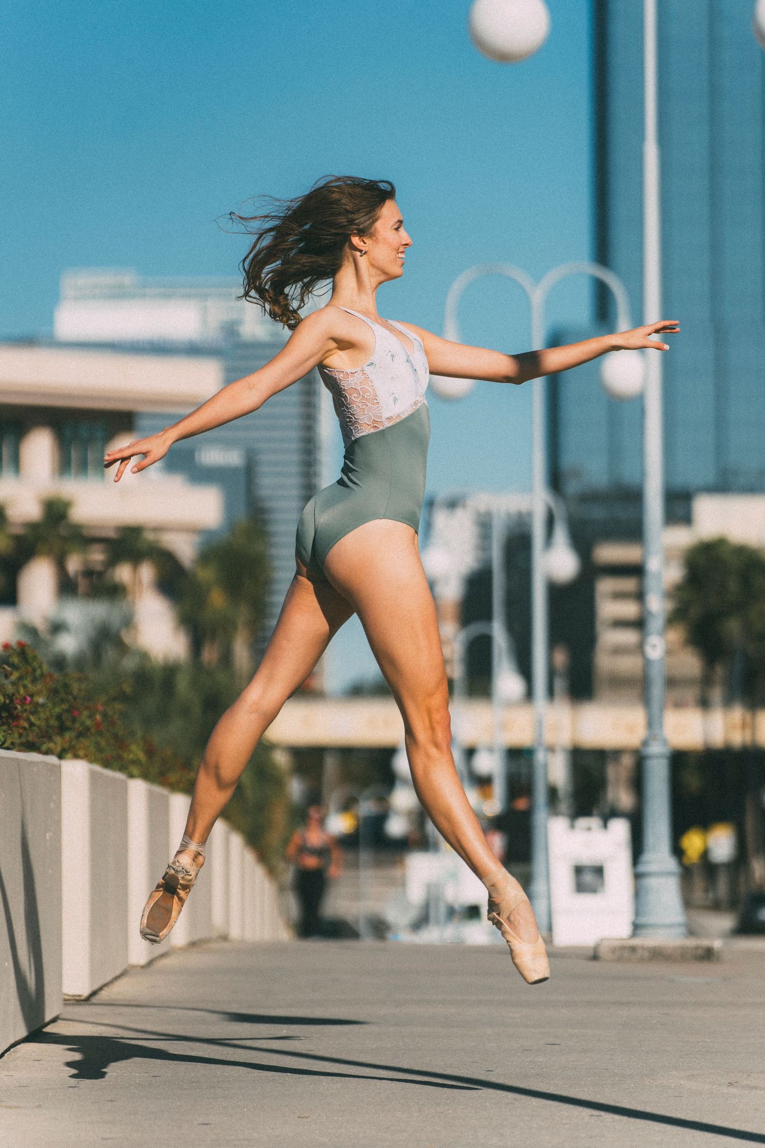 Dance Photographer in Tampa Florida captured a tall ballerina leaping in the air with pointe shoes and leotard