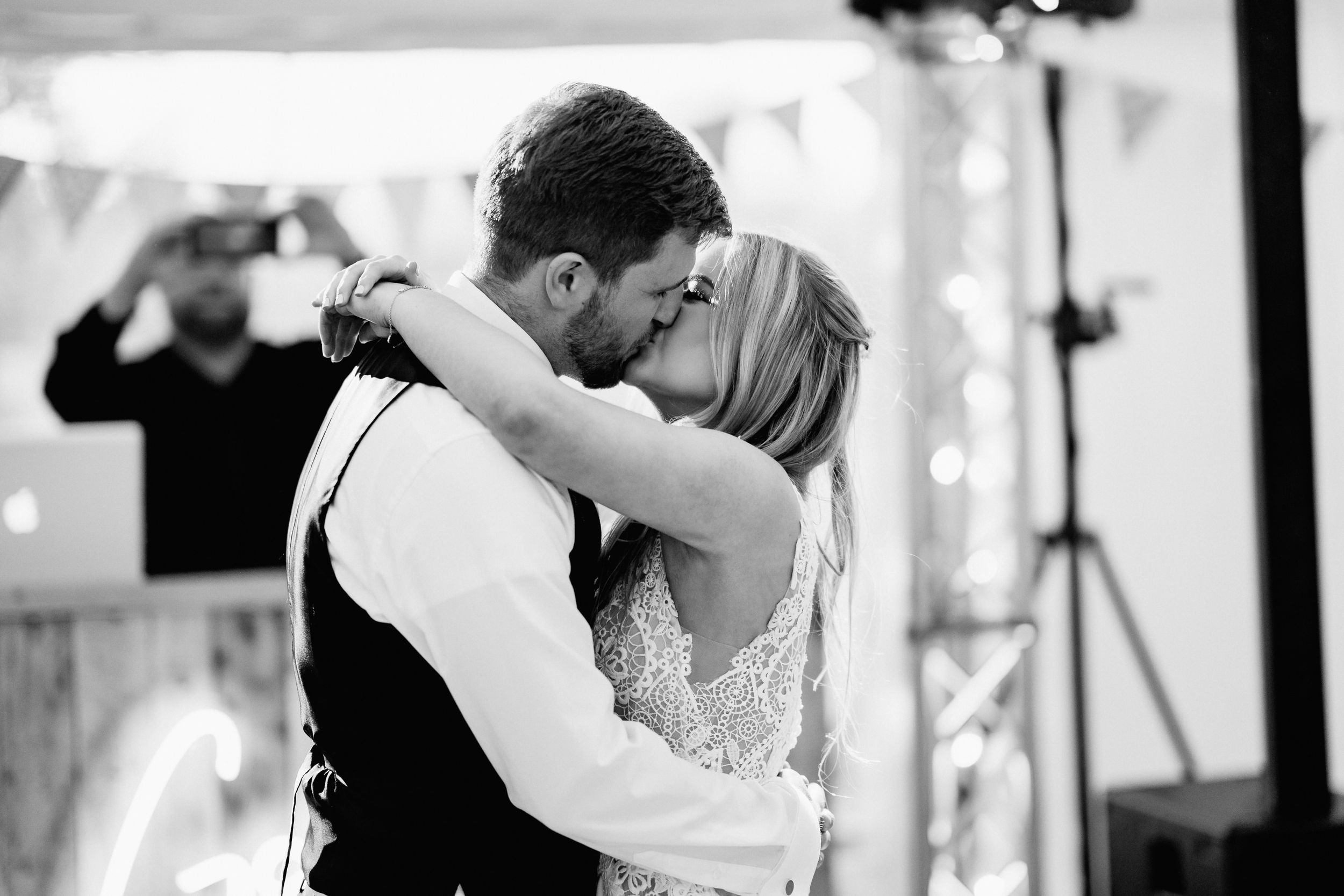A romantic black and white photo of a couple dancing closely together at their wedding reception.