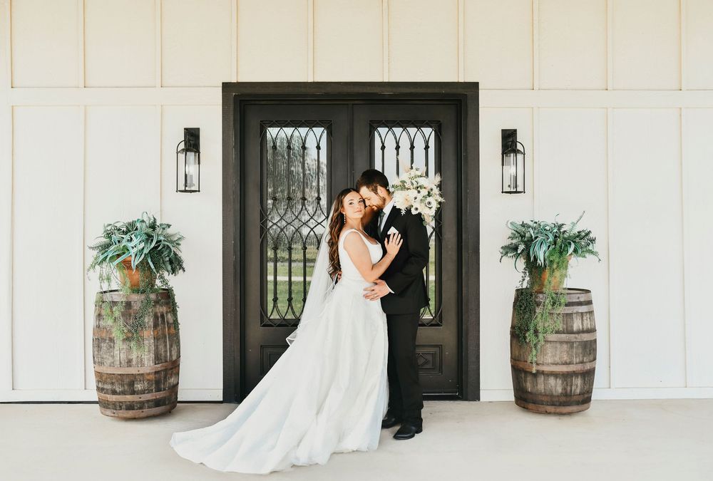 Elegant wedding couple in front of modern farmhouse-style venue