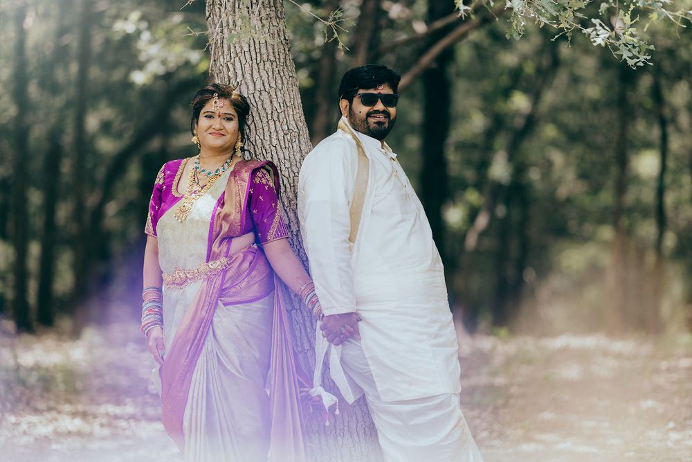 Telugu newly wedded couple in traditional Indian wedding attire pose together in a dreamy forest setting with purple and white clothing.