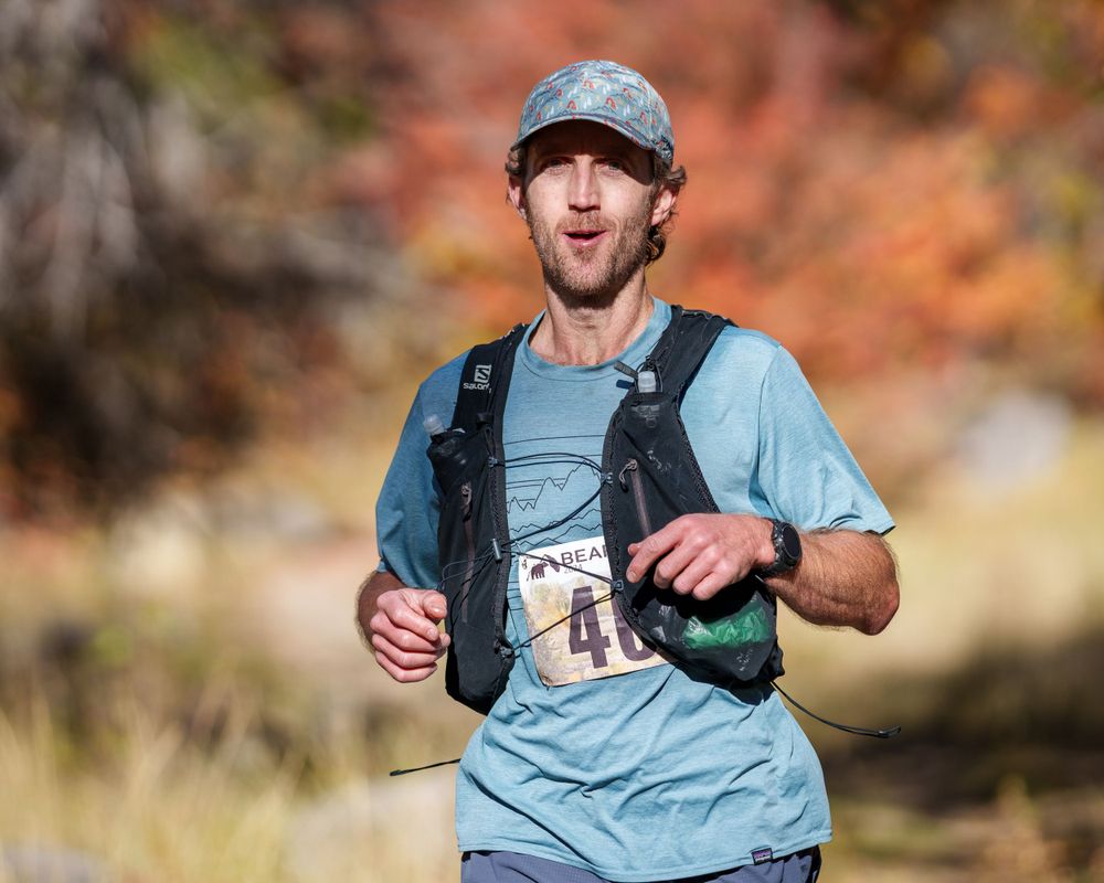 Athlete racing through a forest trail, demonstrating speed and endurance in a trail running competition.