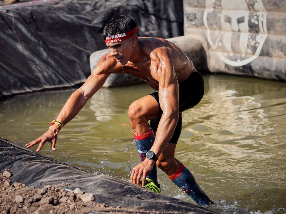 Close-up of a runner’s muddy shoes during an off-road race, emphasizing endurance in trail running events.