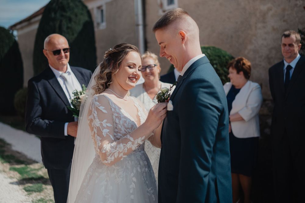 A bride and groom share a tender moment during their outdoor wedding ceremony.