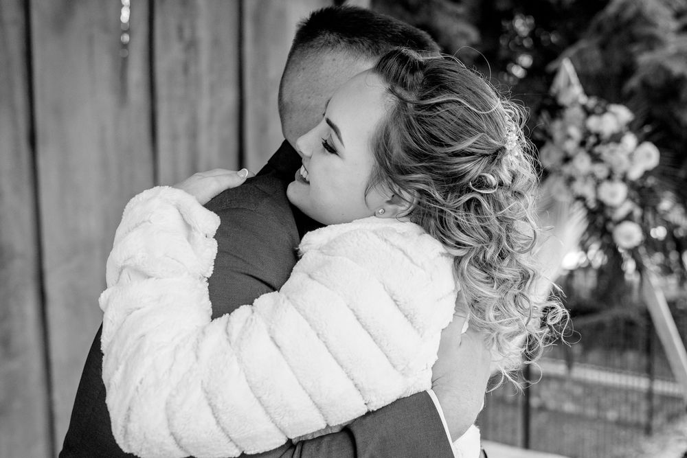A tender black and white wedding moment captured as the couple embraces during their special day.