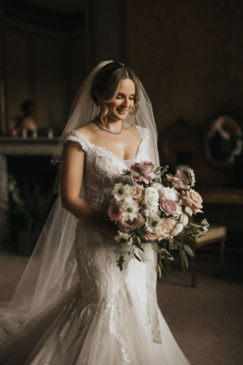 Close-up shots of a bride in a lace wedding dress holding an elegant bouquet of pink and white flowers with greenery.