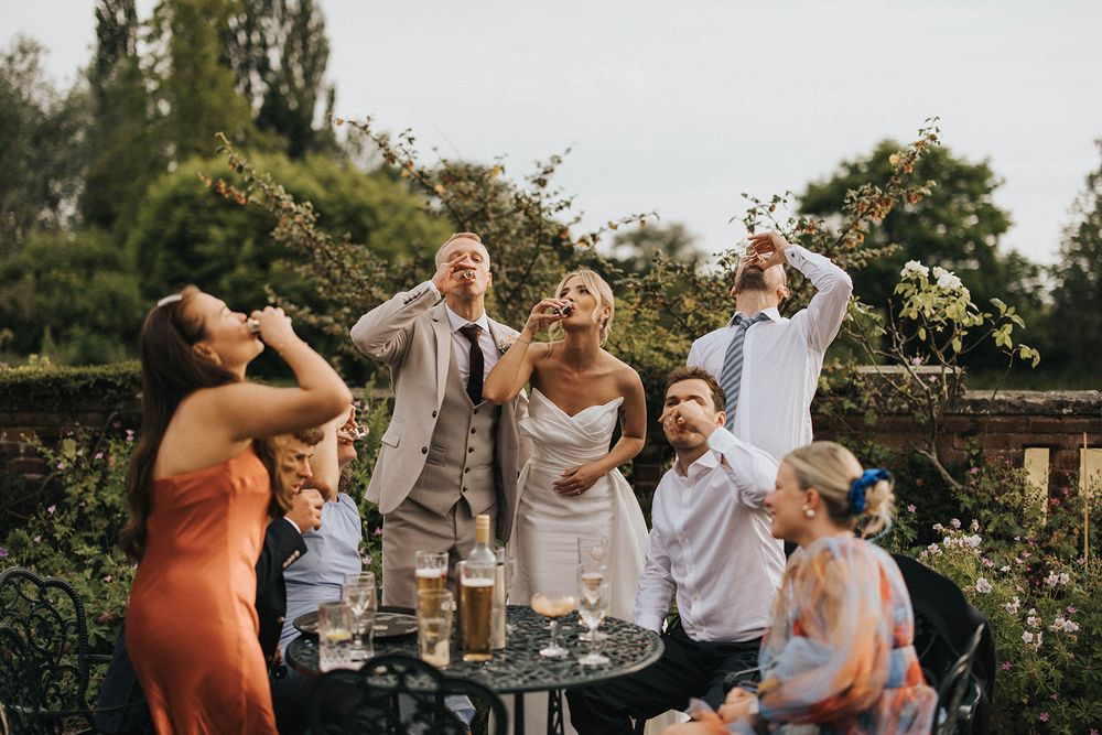 A joyful group celebrating outdoors in a garden setting during a special event.