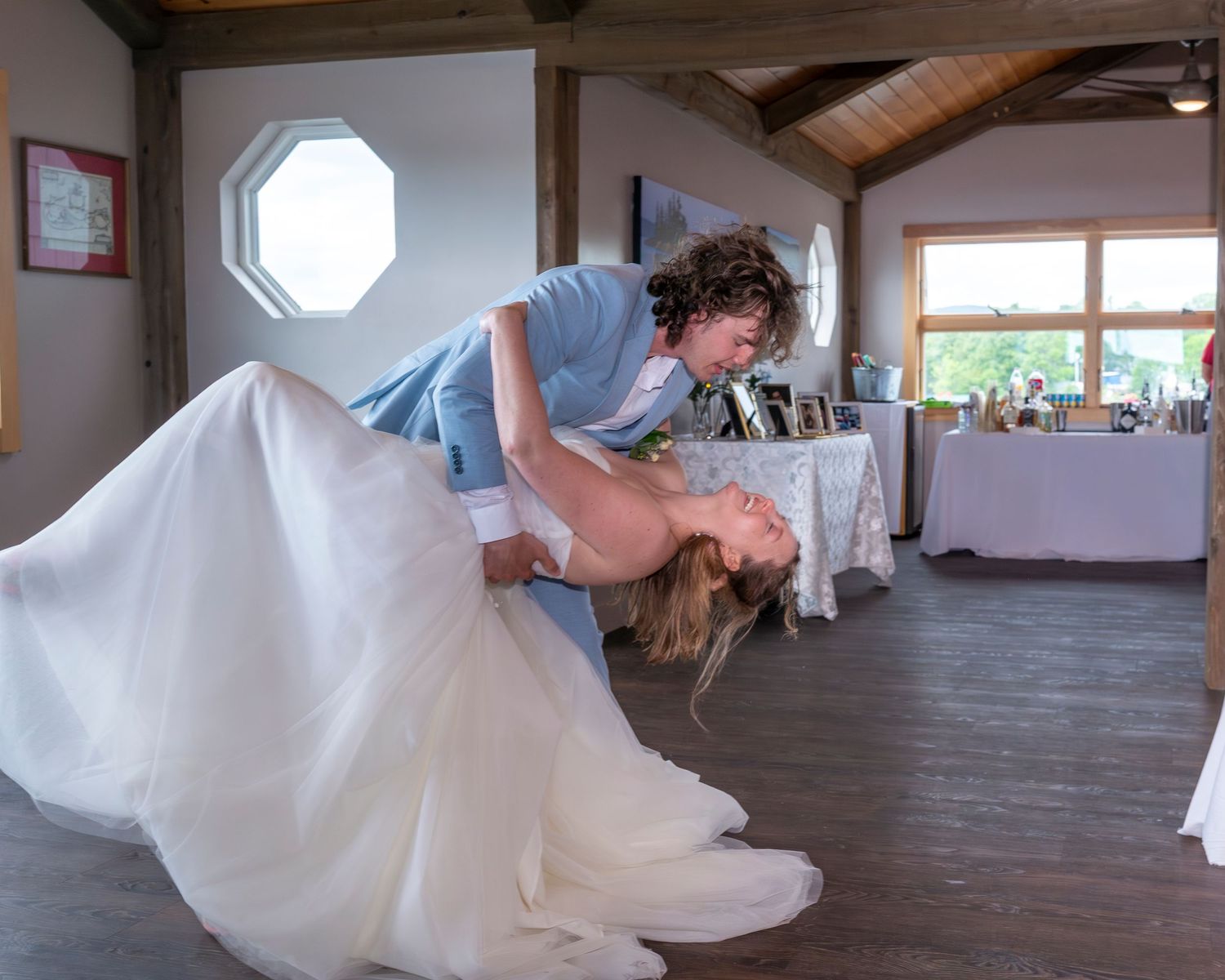 A couple performs a romantic dip during their first dance at a wedding reception