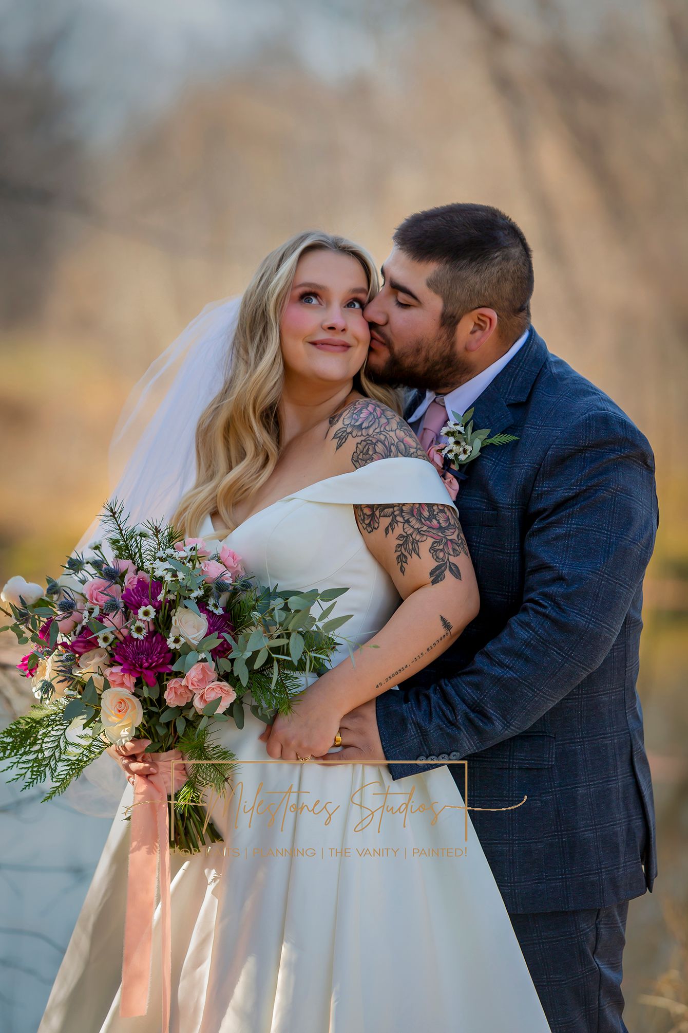 portrait groom kissing bride's cheek