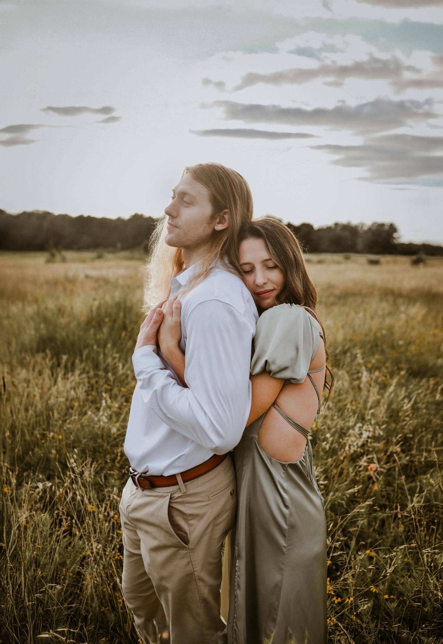 Romantic engagement photo of couple embracing in tall golden grass