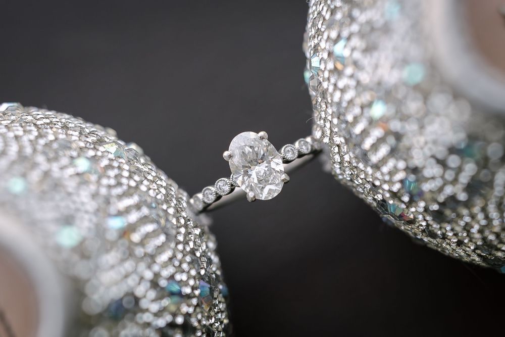 Close-up macro shot of sparkling silver diamond jewelry with intricate details in luxury setting.