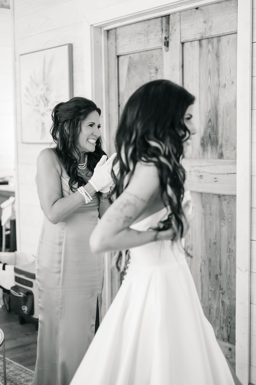 Three black and white photos showing sweet candid moments between bride and mom getting ready before ceremony.