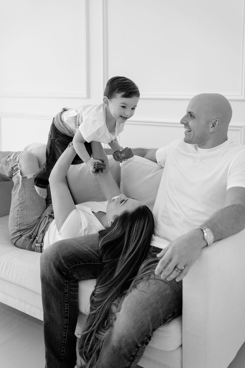 A couple shares intimate moments together on a white couch in a black and white photo collage.