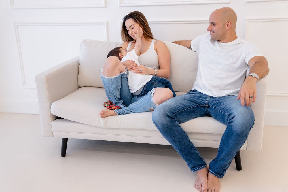 Two people sit together on a white sofa in a modern living room interior.