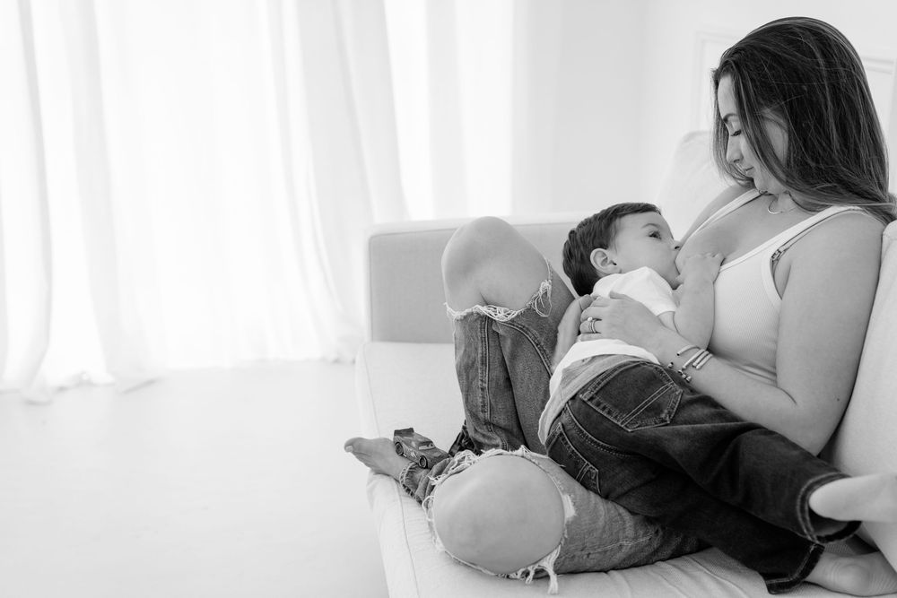 A series of black and white photos showing tender moments of infant care and nursing.