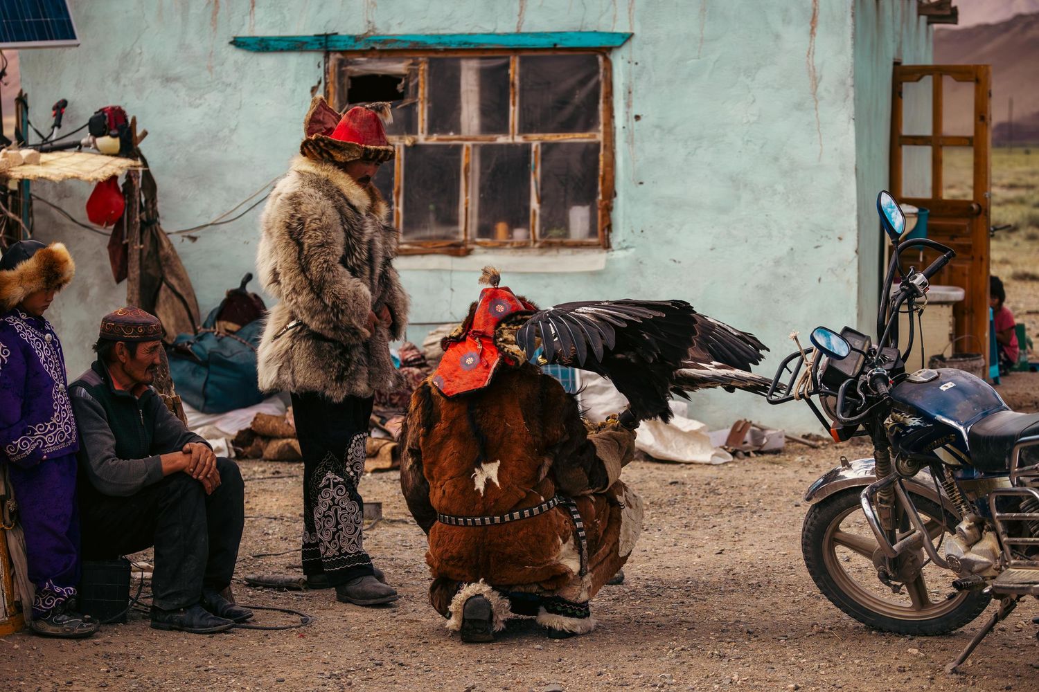 Traditional street scene in Mongolia with locals gathered outside turquoise painted building.