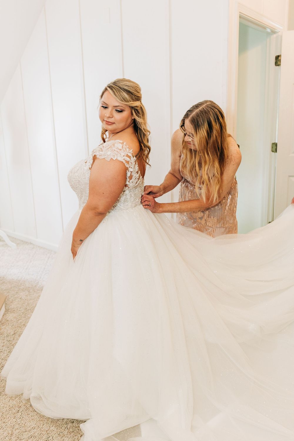 Beautiful motion-filled sequence of twirling white wedding dress with lace details against light colored walls and carpet.