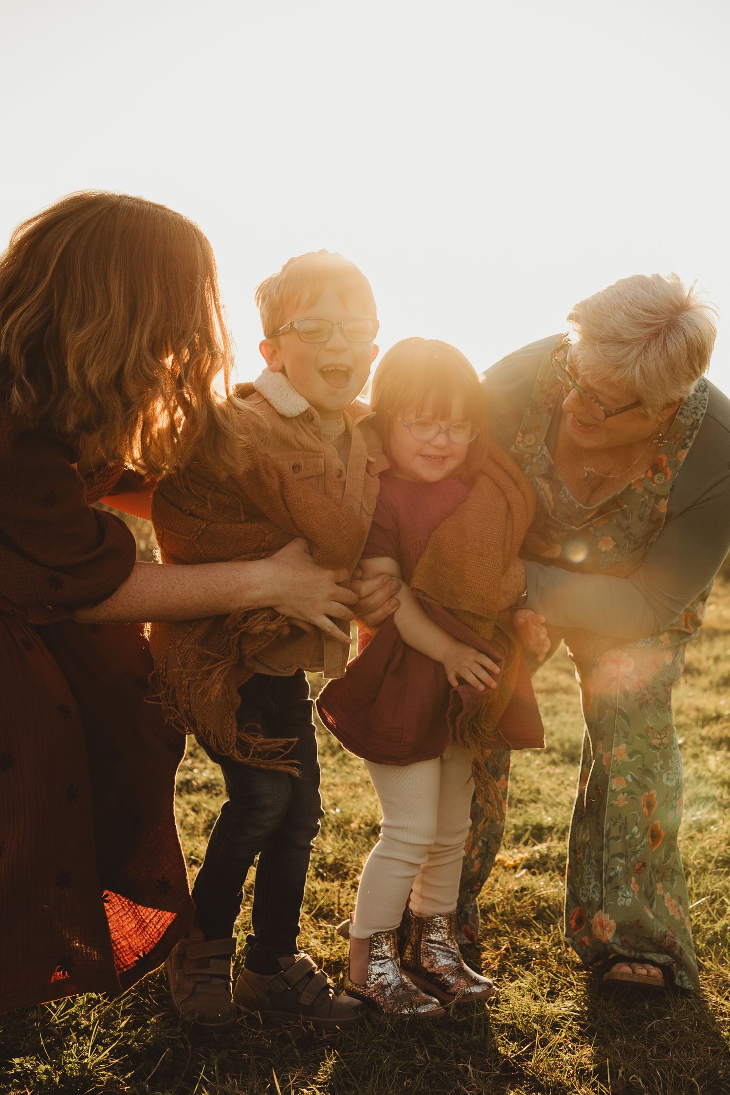 Family enjoying golden sunset in wildflower meadow with their golden retriever on warm summer evening.