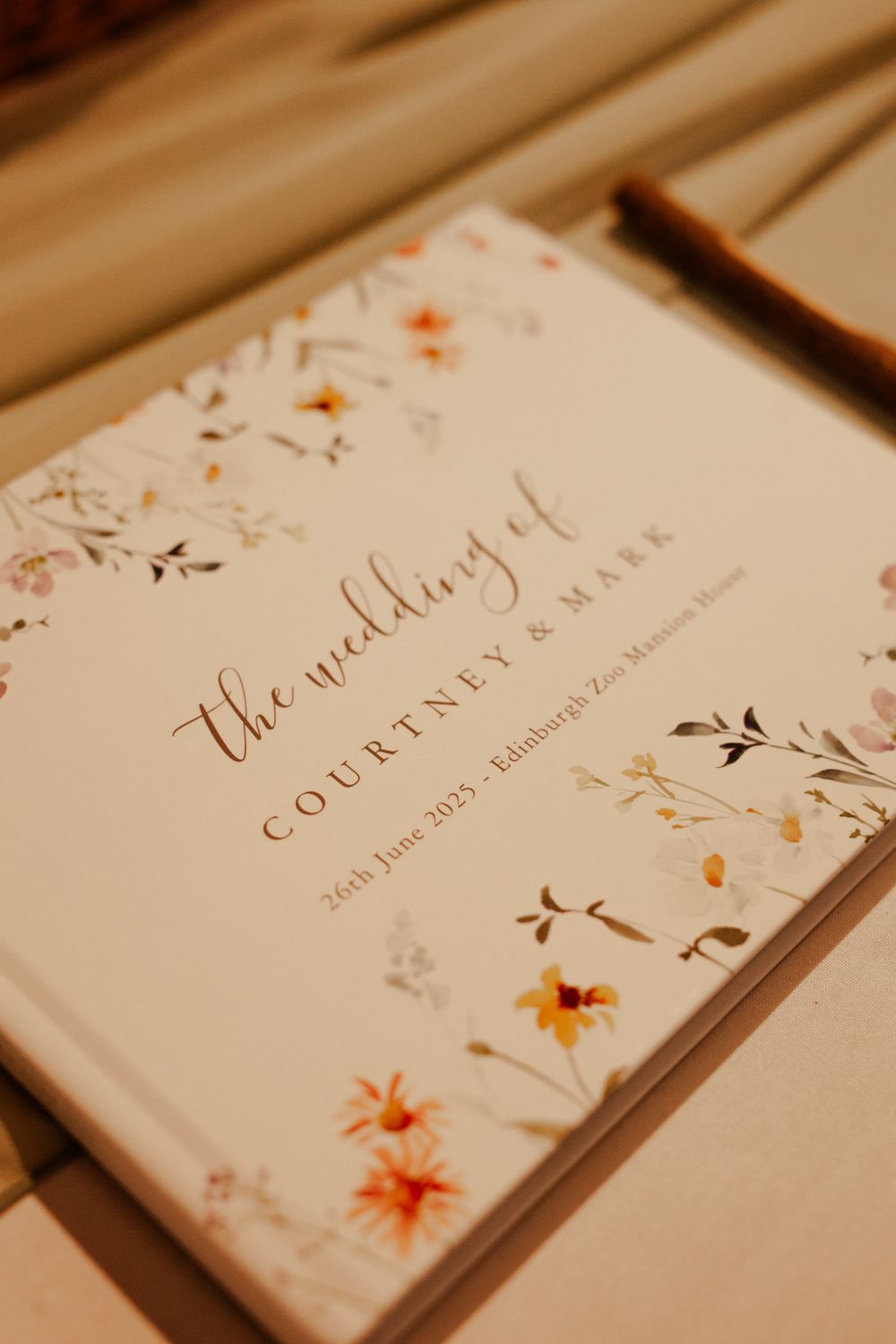 A wedding guestbook with floral design and elegant calligraphy on cream paper.