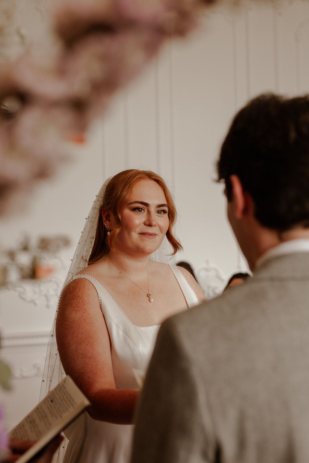 Intimate wedding ceremony moment in a beautifully decorated white room.