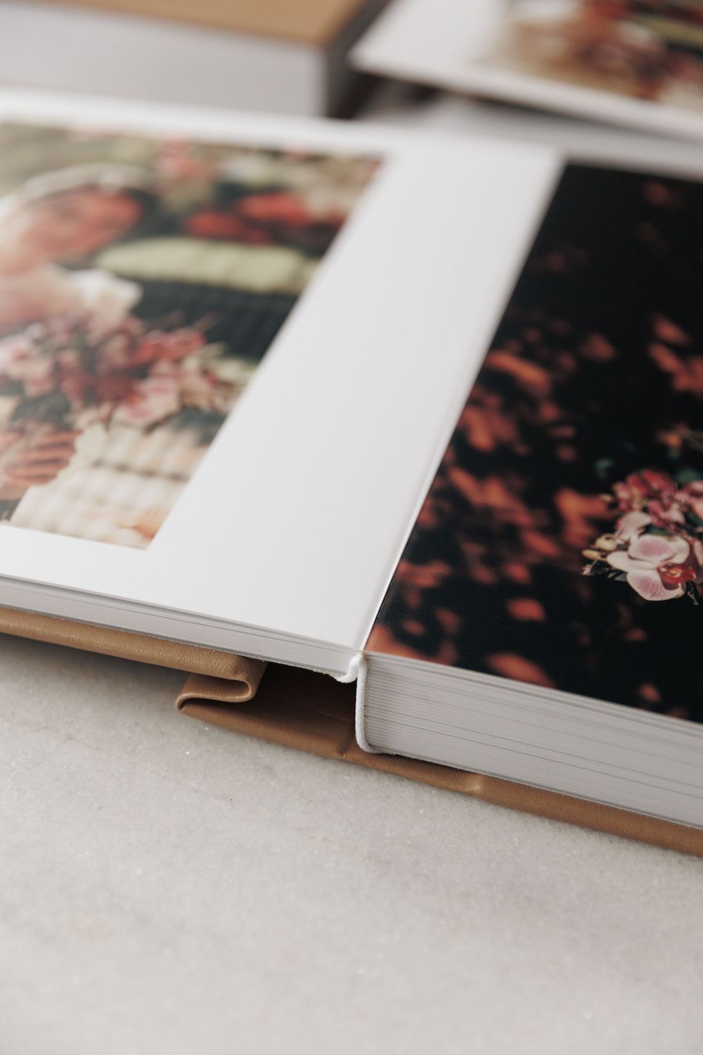 Close-up detail of an elegant white wedding album with photos displayed on textured pages.