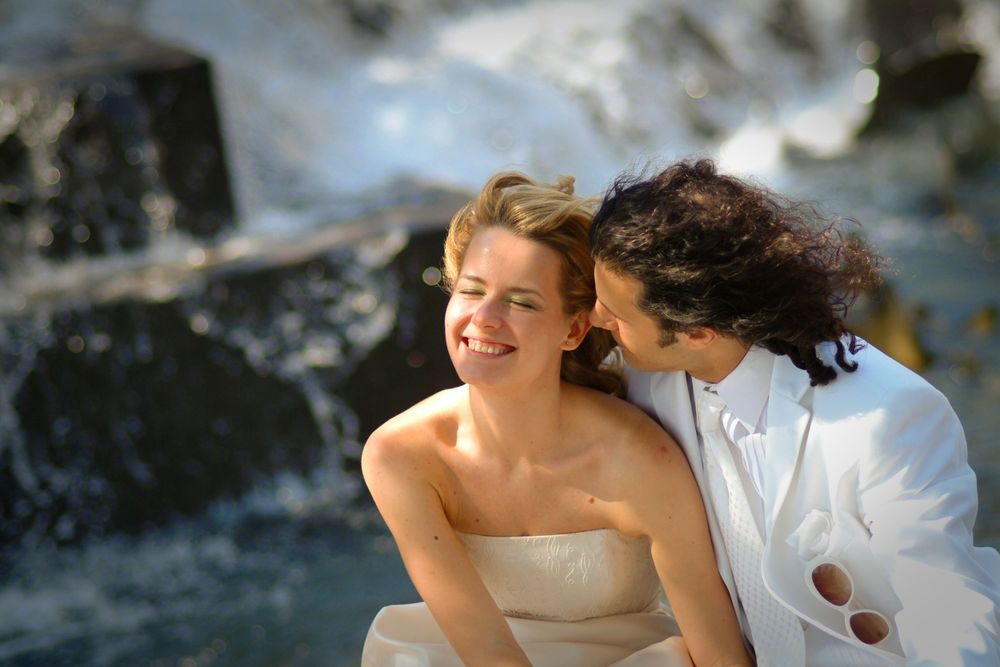 A romantic moment by a cascading waterfall in formal attire.