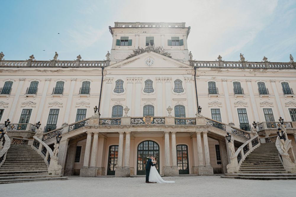 A grand baroque palace with symmetrical double staircases and white facade showcasing elegant classical architecture.