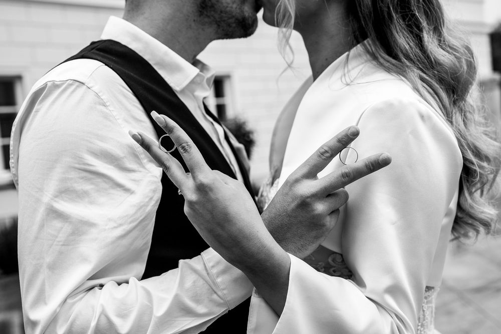 A romantic black and white close-up photograph shows a tender moment between two people embracing.