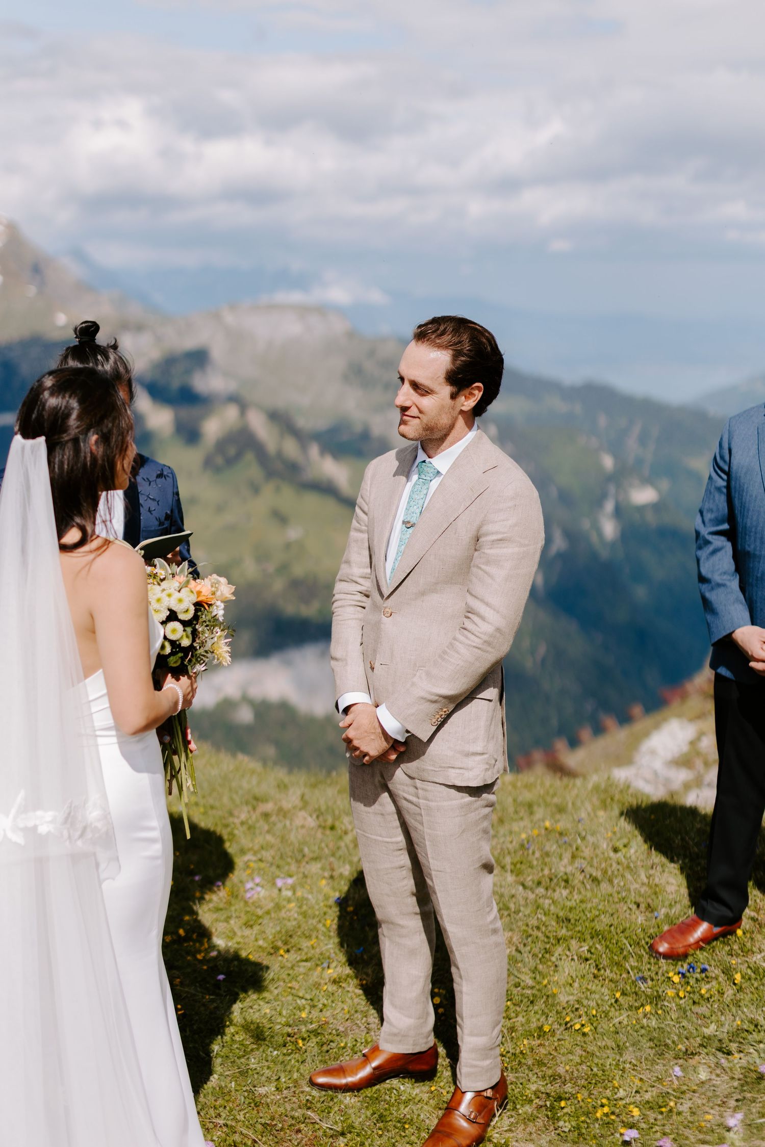 Wedding ceremony set on a scenic mountain summit with dramatic Alpine peaks in the backdrop.