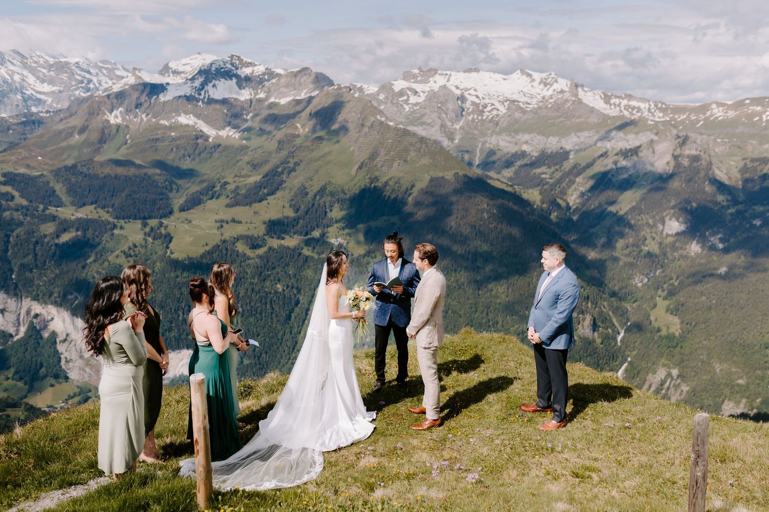 An intimate mountain-top wedding ceremony with dramatic Alpine peaks in the background.