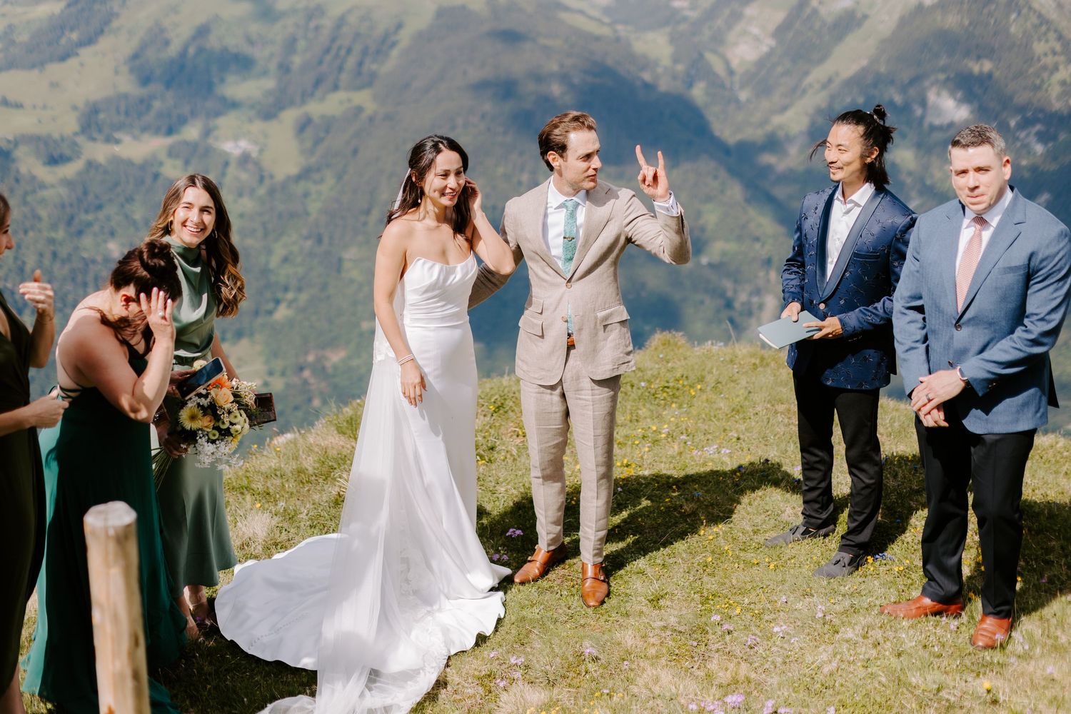 Wedding ceremony taking place on a scenic mountain summit with dramatic peaks in the background.