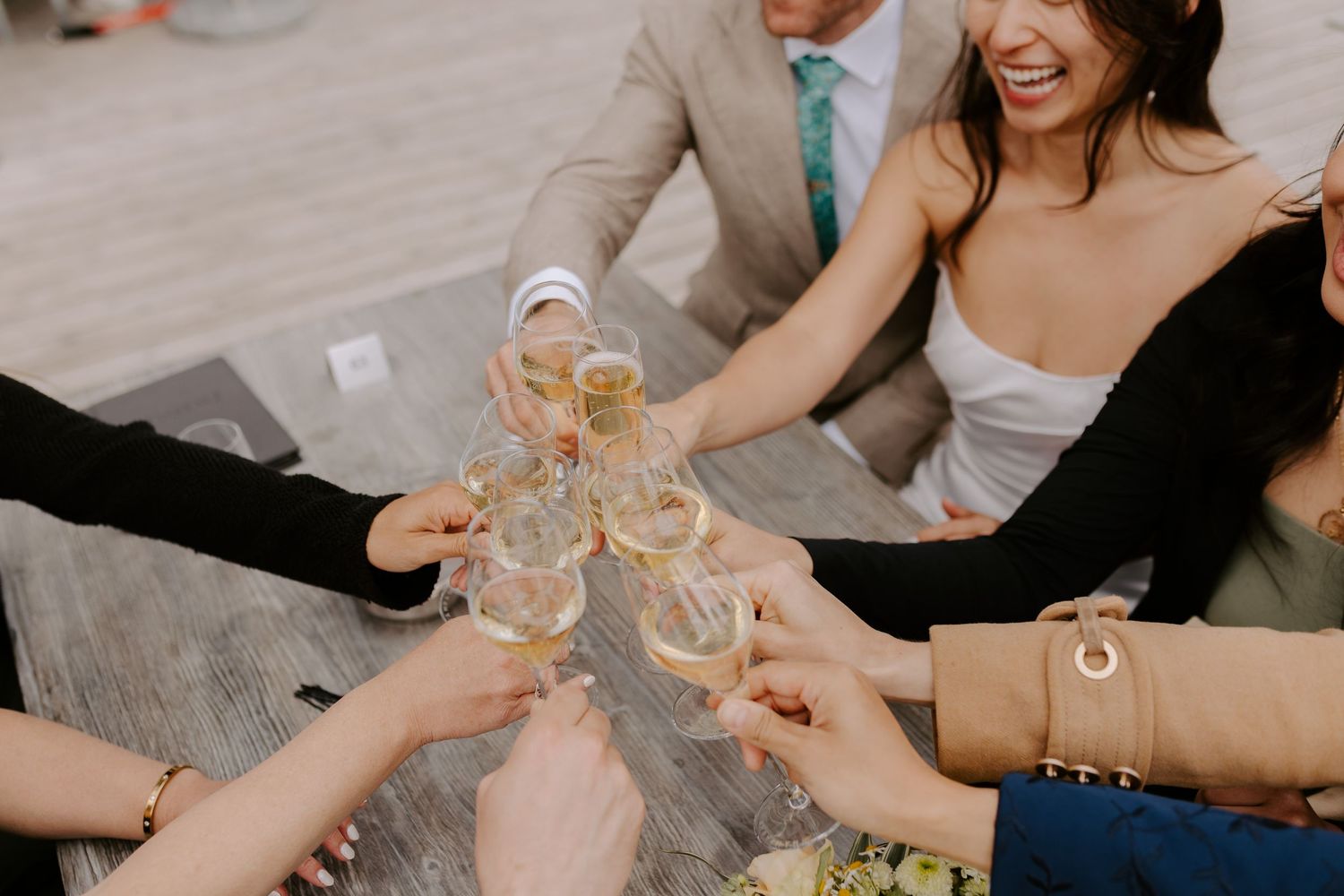 Group toasting with champagne glasses at wedding celebration.