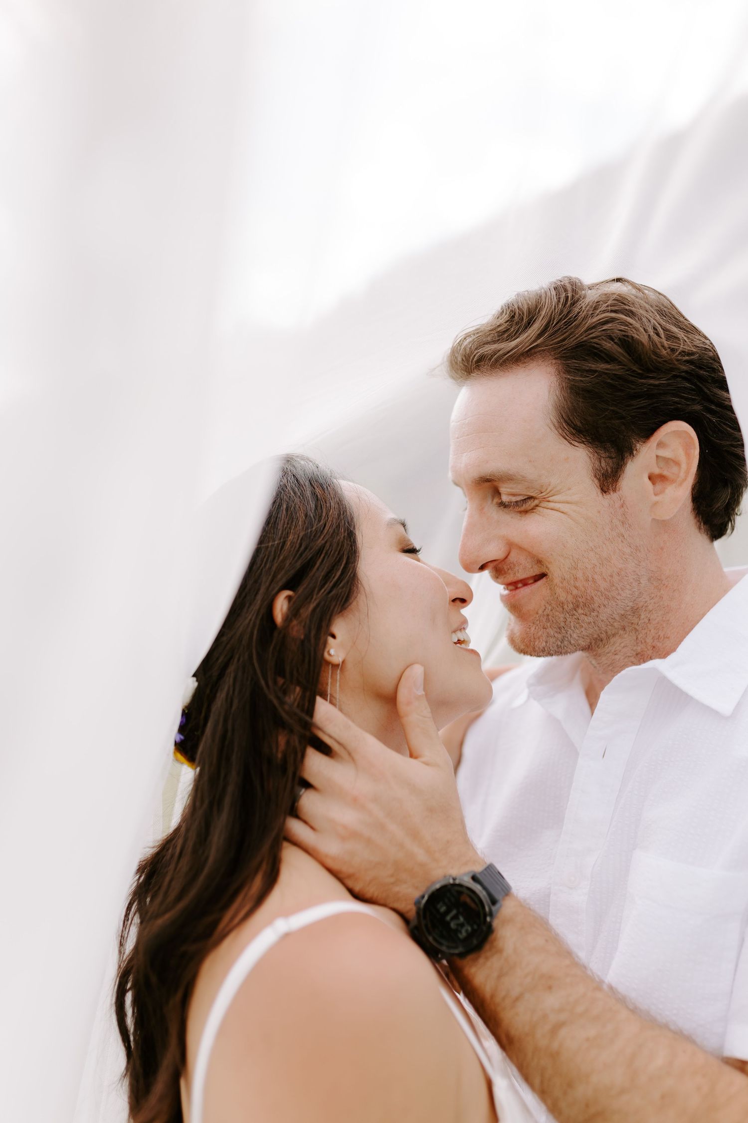 Intimate close up profile shots of a couple about to kiss against a bright white background.