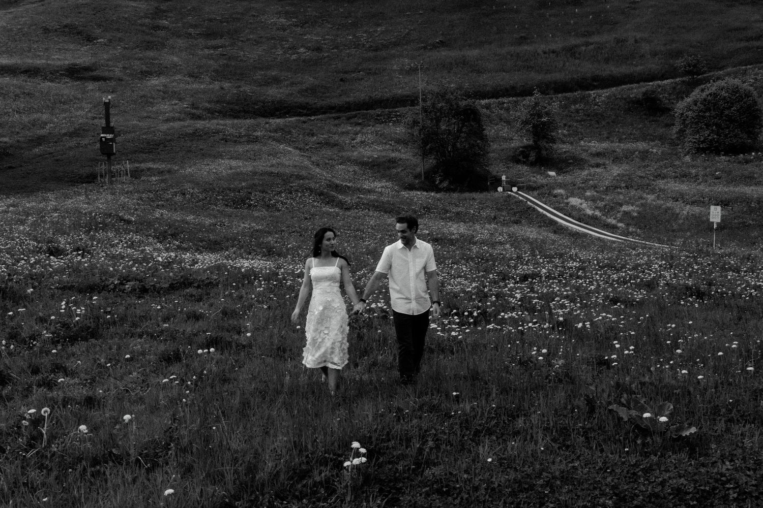 Silhouettes of people walking along a scenic hillside path at dusk.