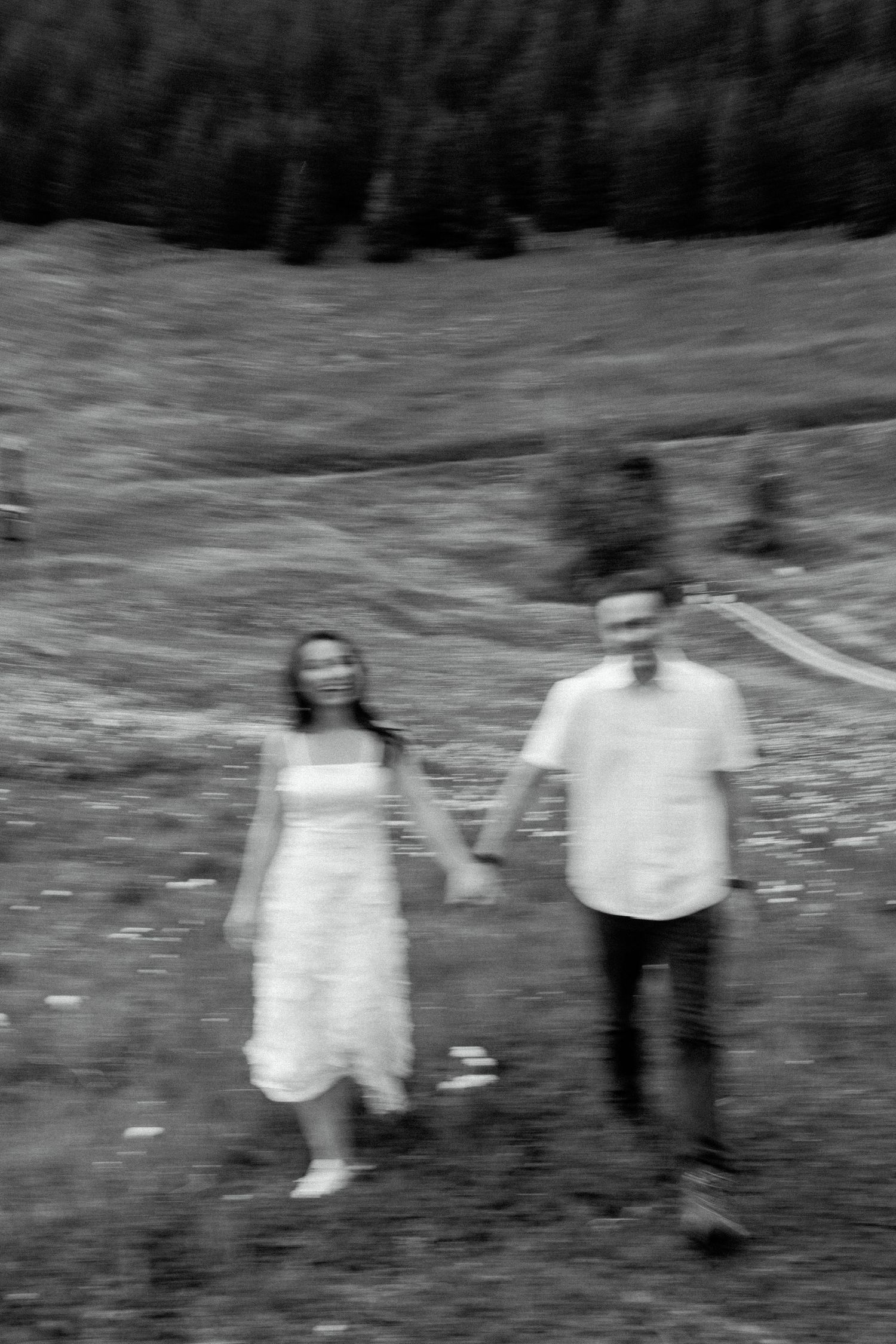 Black and white image of figures walking together across a grassy landscape.