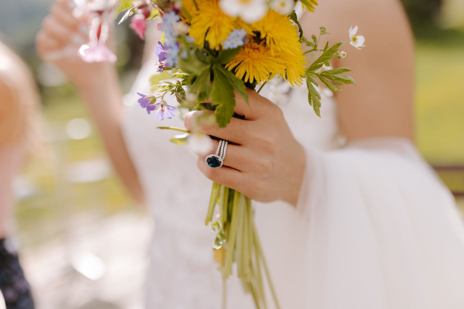Close up of vibrant yellow and purple wildflowers in a rustic wedding bouquet.