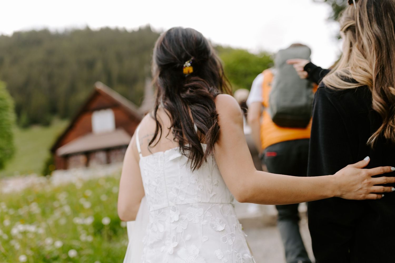 An intimate moment captured at a rustic mountain wedding with a cabin in the meadow background.