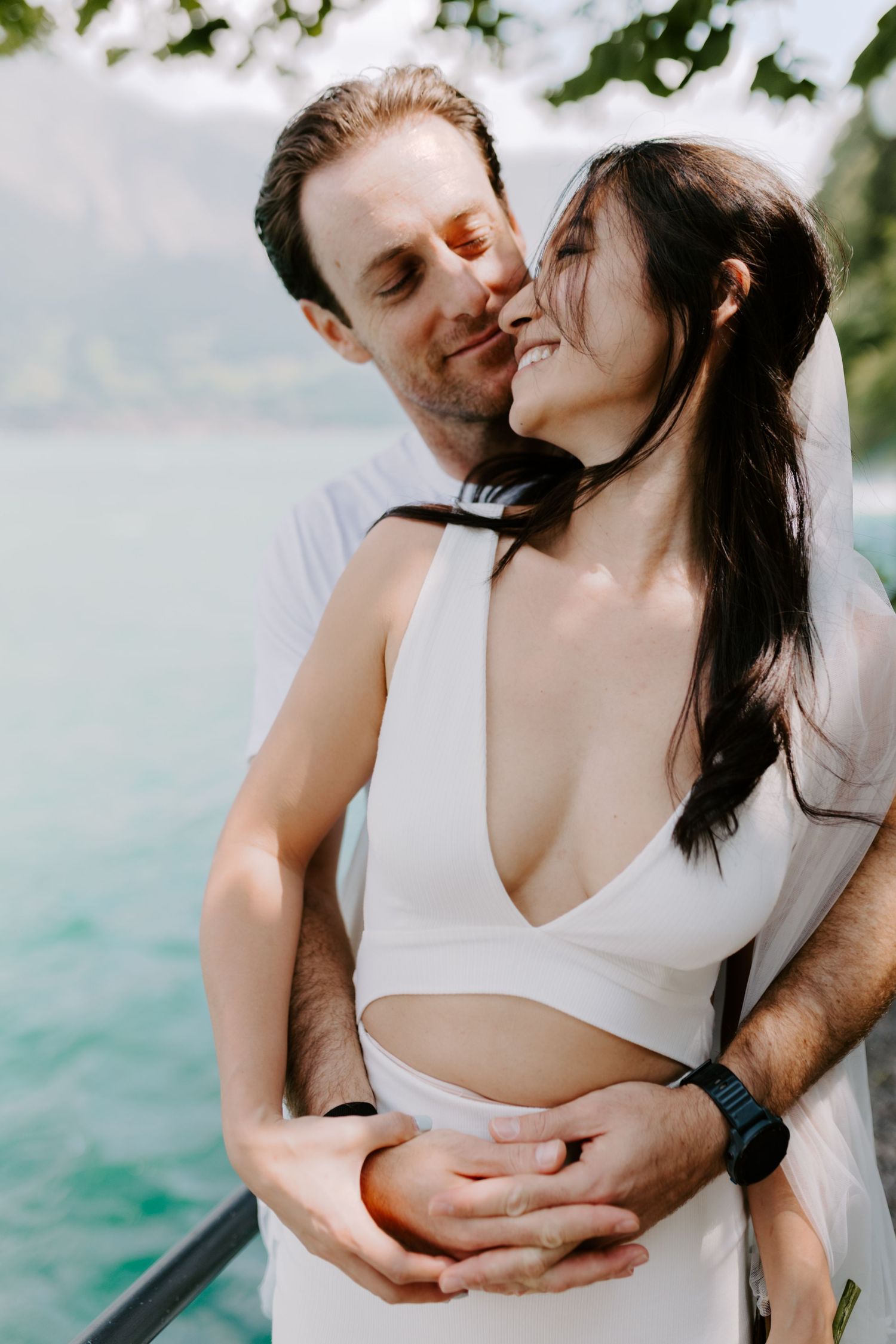 Intimate moment between couple against backdrop of blue alpine lake.