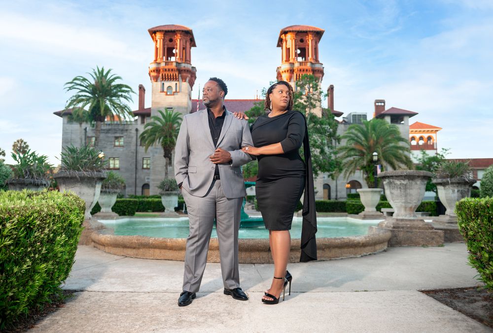 Grace and Jay walk hand-in-hand through the courtyard of the Lightner Museum, captured by luxury wedding photographers in Florida.