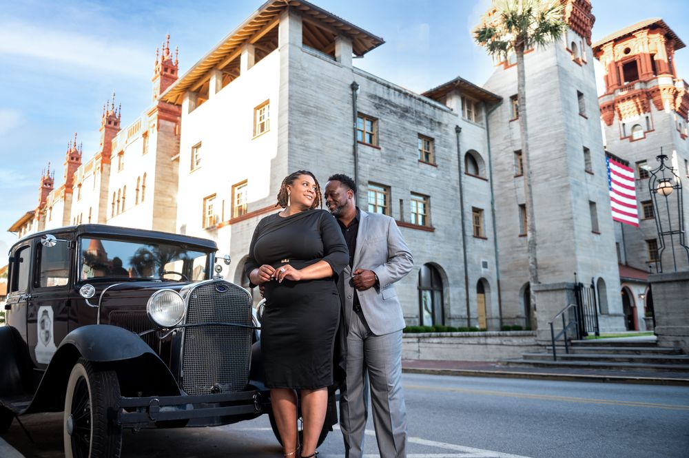 Jay kisses Grace’s forehead near the stone fountain at the Lightner Museum, documented by Florida destination wedding photographers.