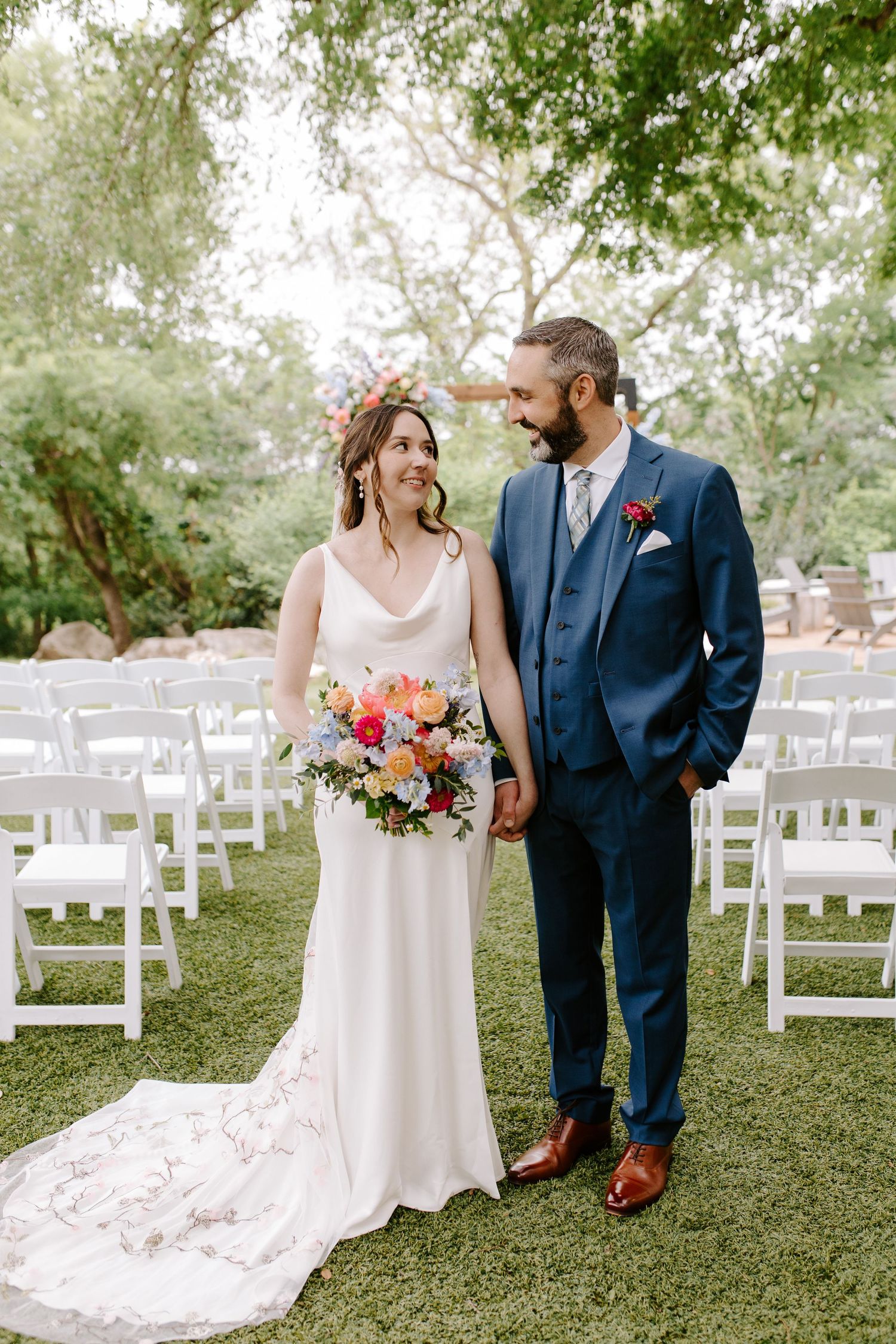 Couple in wedding attire sharing intimate moments in an outdoor garden setting.