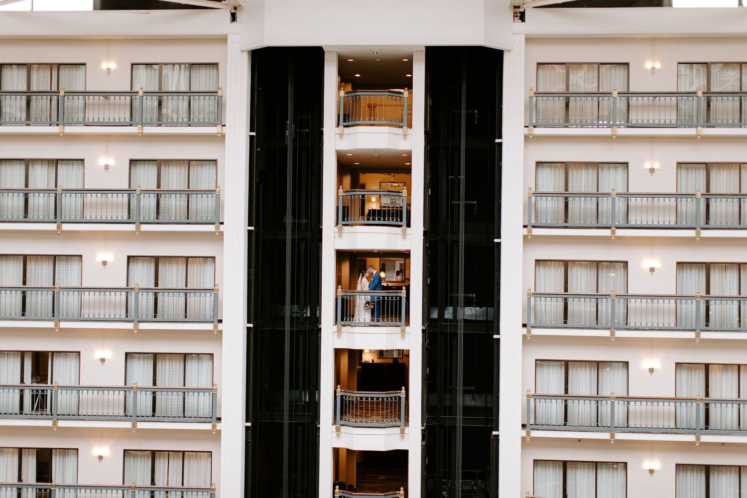 Modern apartment building exterior with glass balconies and geometric architecture.