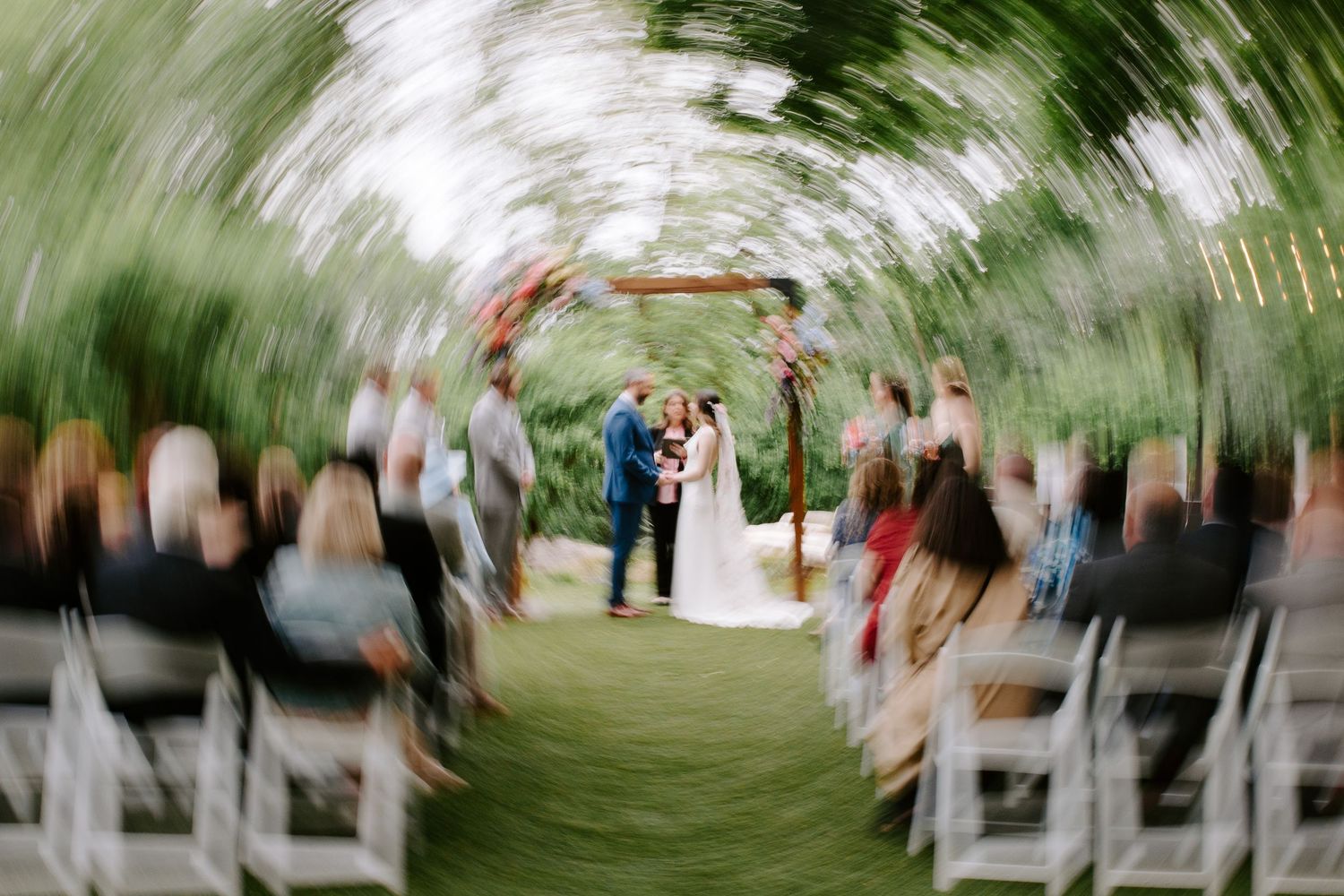 Abstract motion blur photograph of an outdoor wedding ceremony setup.
