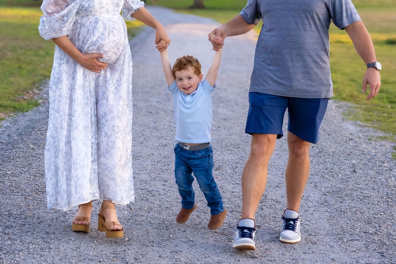 family walks and holds hands where you can only see little boy during family session in Athens, GA - Athens & Bogart family photographer