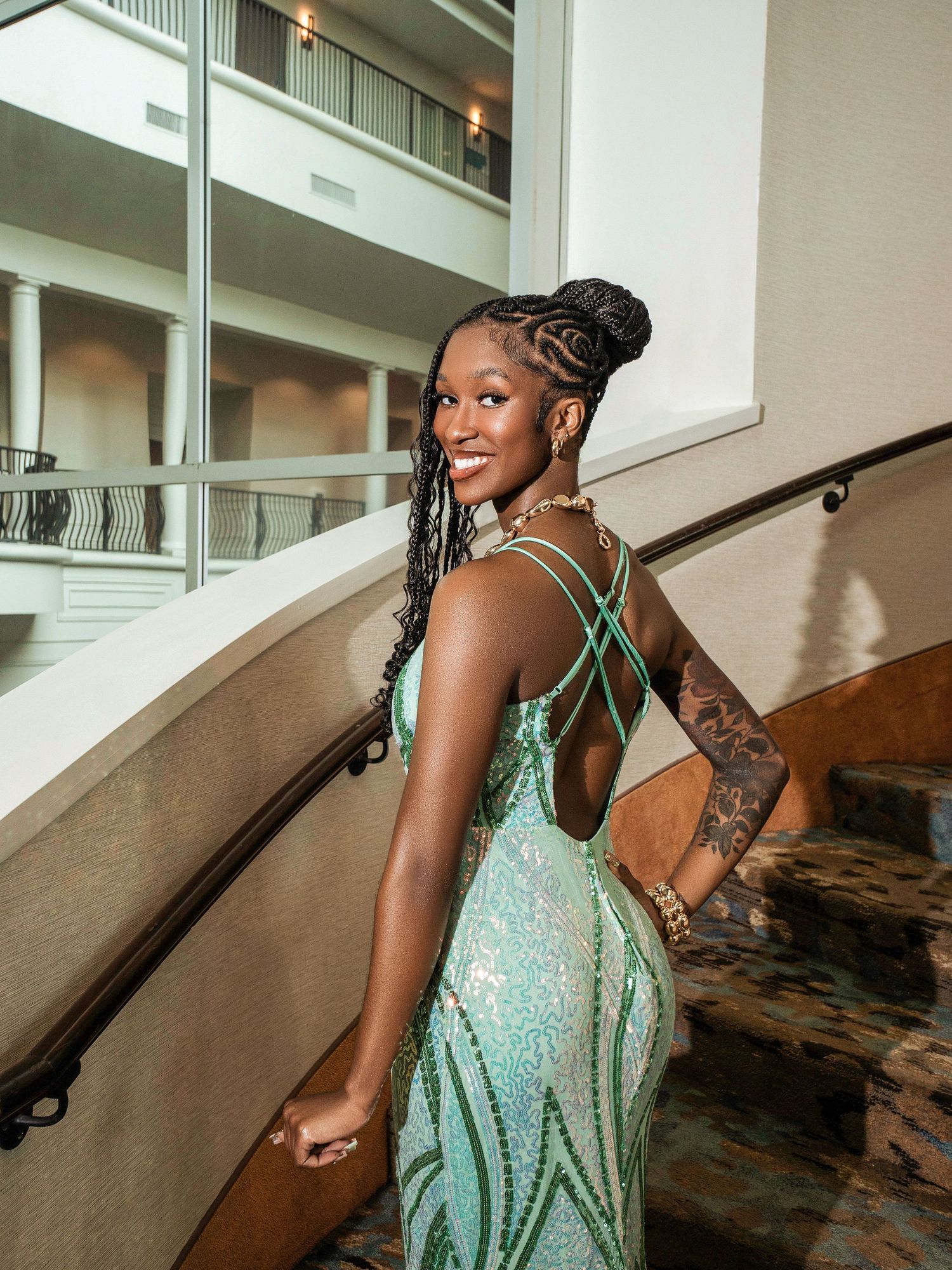 Back view of sparkly mint green formal dress with criss-cross straps and flowing mermaid silhouette.