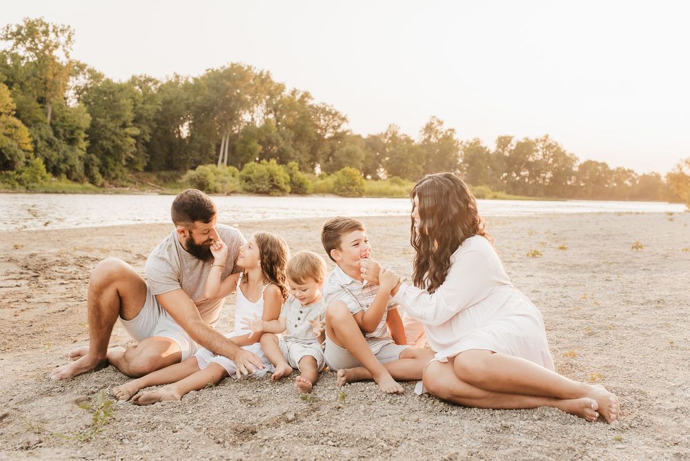 gorgeous family laughs together on the beaches of the little Miami river