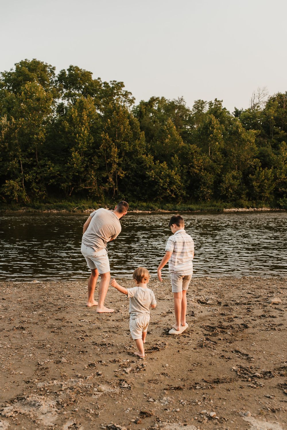 family skips rocks on little Miami river outside of cincinnati, ohio