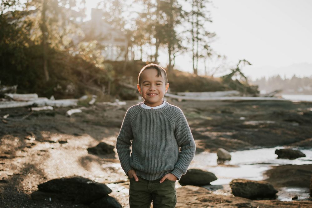 Parksville photographer portrait of young son during family photoshoot at Madrona Point Beach on rocky shore on Vancouver Island