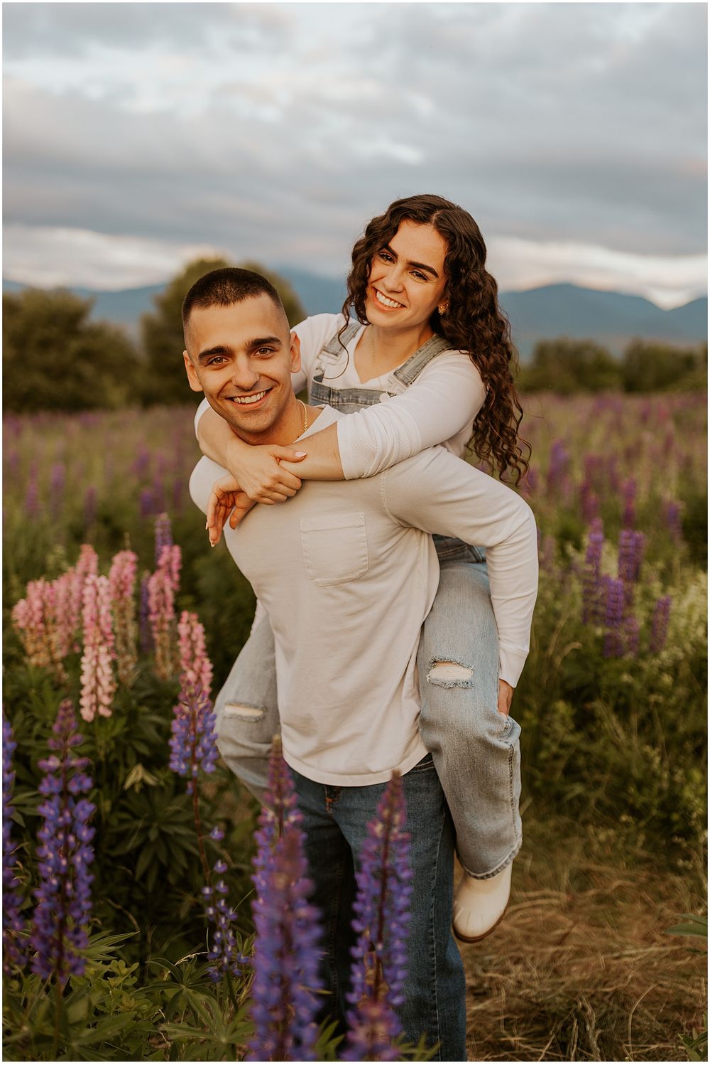 NH couple taking engagement photos in a lupine field