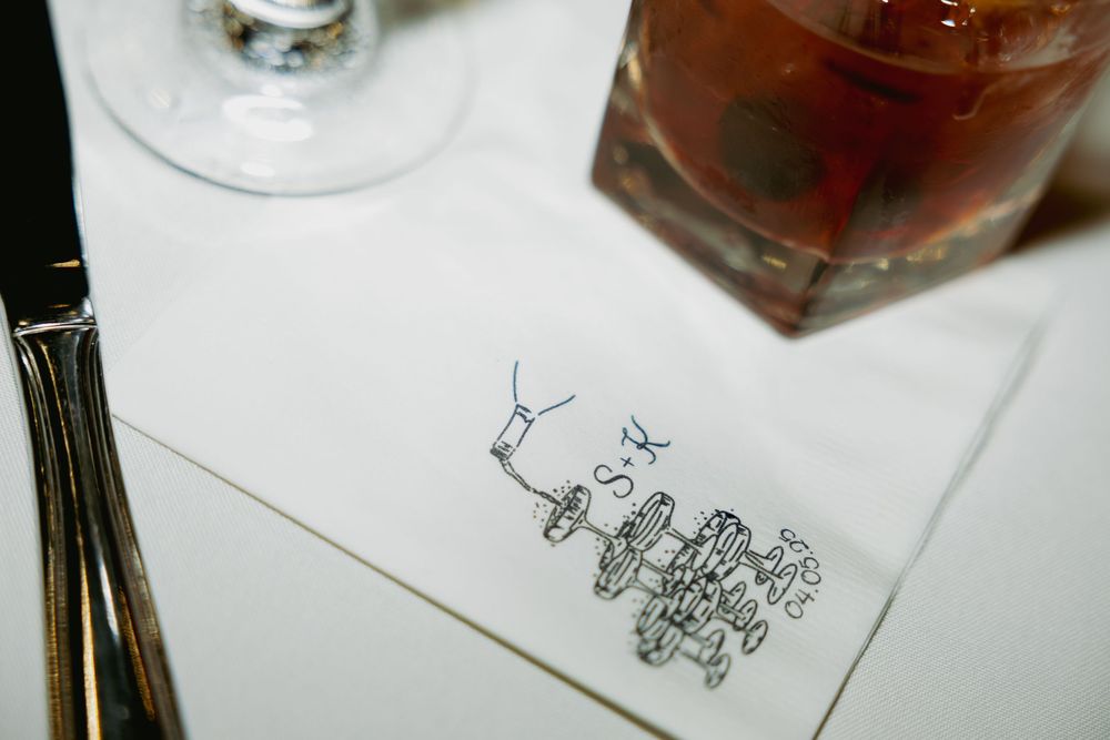 A simple hand-drawn doodle on white paper sits next to a glass and a brown beverage.