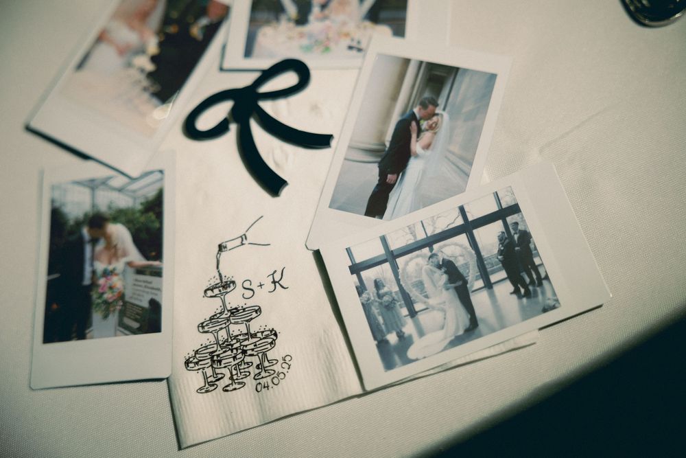 A collection of vintage polaroid photographs and a black ribbon bow arranged on a light surface.